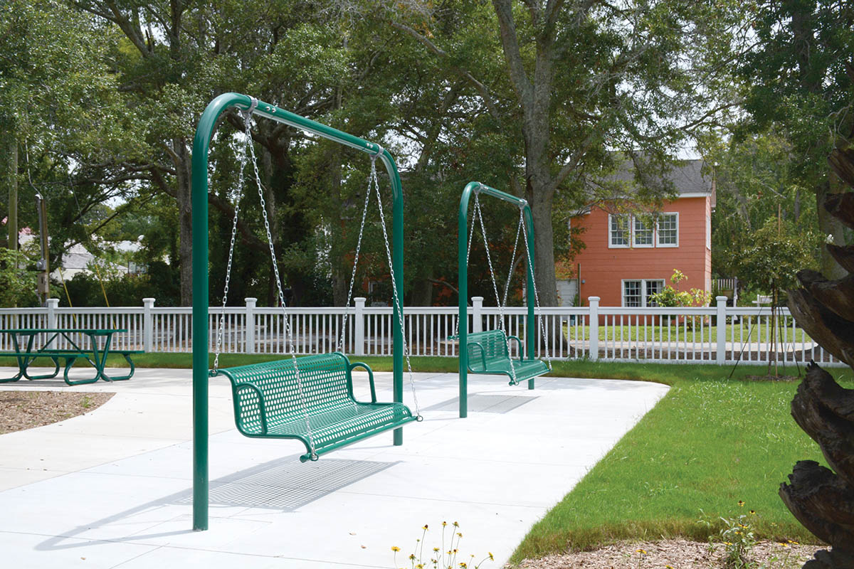 Bench swings look out over Alhambra Hall’s lawn, with Charleston Harbor just beyond.
